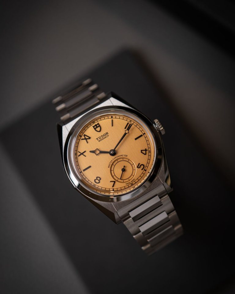 TUDOR Monarch auf Uhrenkissen einer Uhrenrolle vor grauem Hintergrund