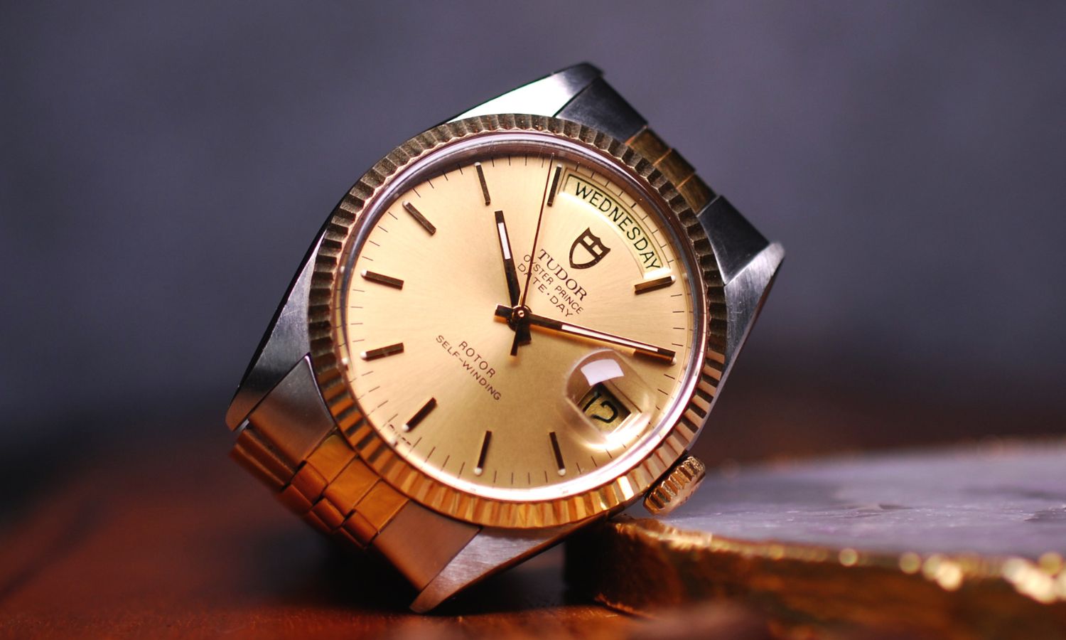 TUDOR Oyster Prince Date-Day Referenz 94613 mit goldenem Zifferblatt am Edelstahlarmband seitlich von vorne abgebildet