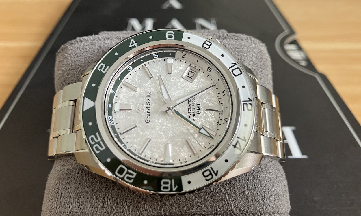 Grand Seiko SBGJ277 liegend auf Buch "A Man and his Watch".